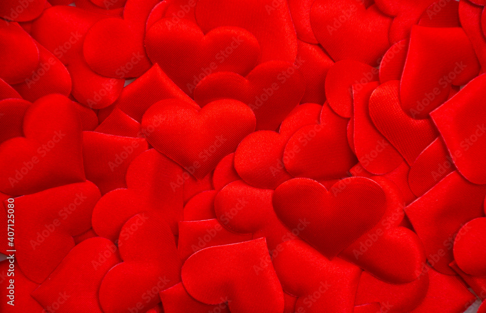Many textured red hearts lie on top of each other: valentine's day background, seamless heart pattern, group heart for background