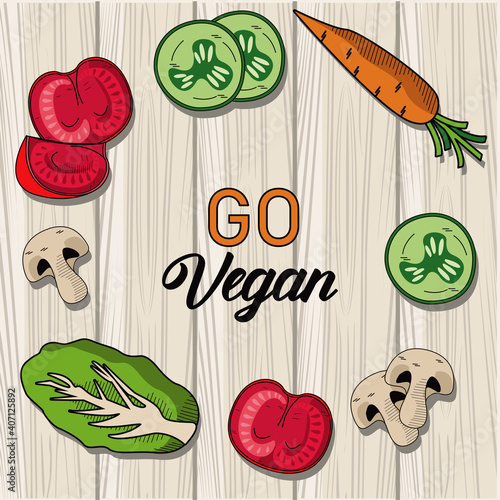 go vegan lettering poster with vegetables around in wooden background