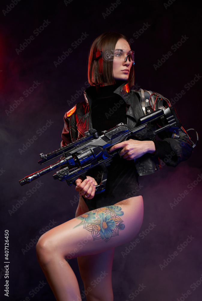 Sexual female warrior with nude and tattooed legs poses in dark and smokey background. Armed with futuristic armed beautiful woman with cybernetic implant. Sexual female warrior with nude and tattooed legs poses in dark and smokey background. Armed with futuristic armed beautiful woman with cybernetic implant.