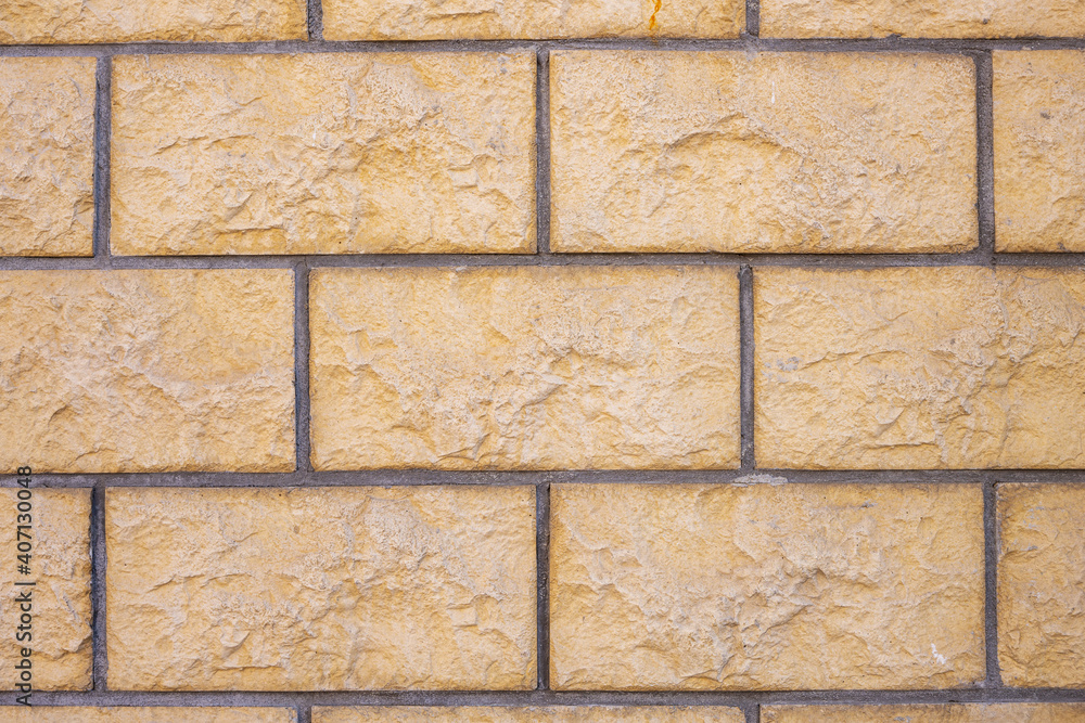 Background from a wall with beige block-shaped bricks Background from a wall with beige block-shaped bricks
