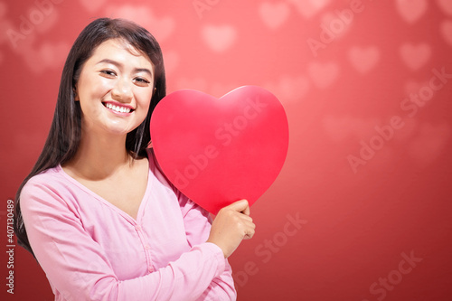 Asian woman holding the red heart