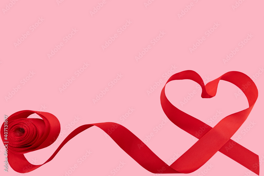 Red ribbon in the shape of a heart on a pink background. The concept of Valentine's Day. A postcard for expressing feelings. Free space. Minimalism.