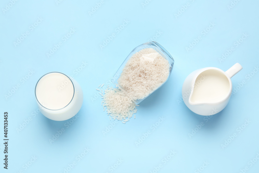 Jug and glass of rice milk on color background Jug and glass of rice milk on color background