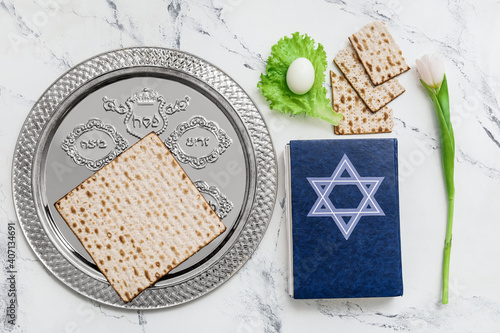 Passover Seder plate with traditional food and Torah on white background photo