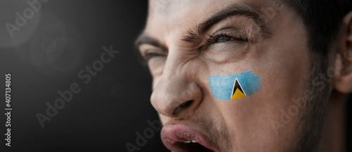 A screaming man with the image of the Saint Lucia national flag on his face