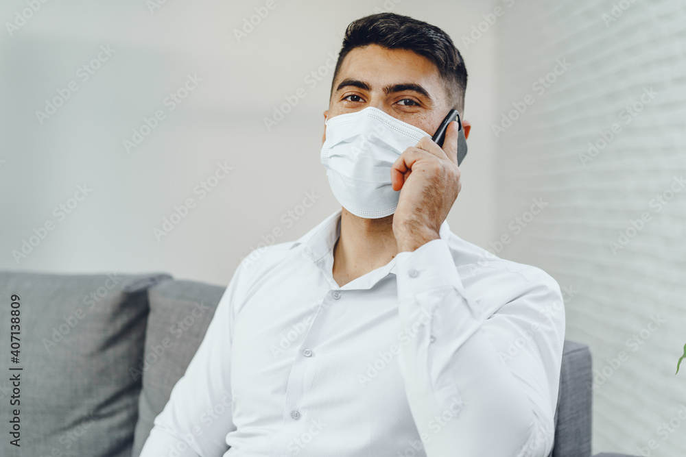 Handsome young businessman with face mask talking on the phone Handsome young businessman with face mask talking on the phone