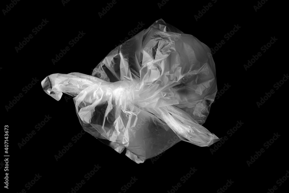 White plastic bag isolated on black. Empty crumpled plastic bag isolated on a black background. Used plastic bag is intended for recycling.
