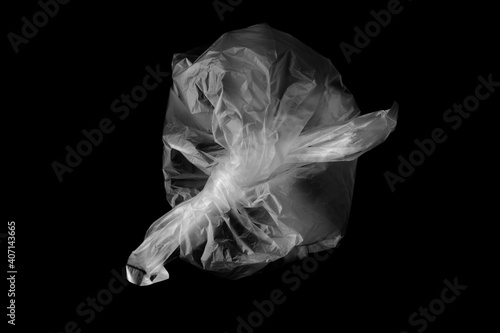White plastic bag isolated on black. Empty crumpled plastic bag isolated on a black background. Used plastic bag is intended for recycling.