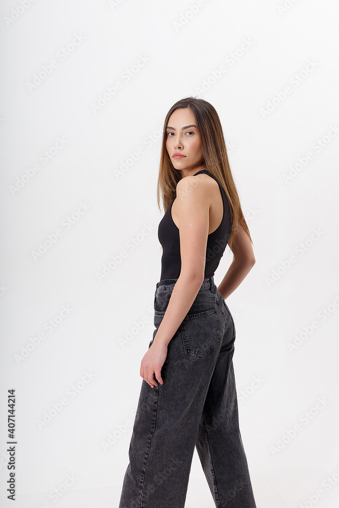 portrait of young attractive asian woman with long hair in black bodysuit, jeans, isolated on white studio background. skinny pretty female posing on cyclorama. model tests of beautiful lady portrait of young attractive asian woman with long hair in black bodysuit, jeans, isolated on white studio background. skinny pretty female posing on cyclorama. model tests of beautiful lady