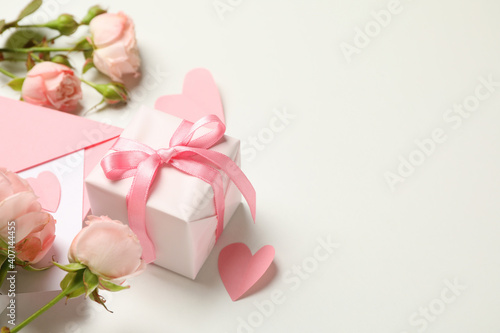 Envelope, roses, hearts and gift box on white background