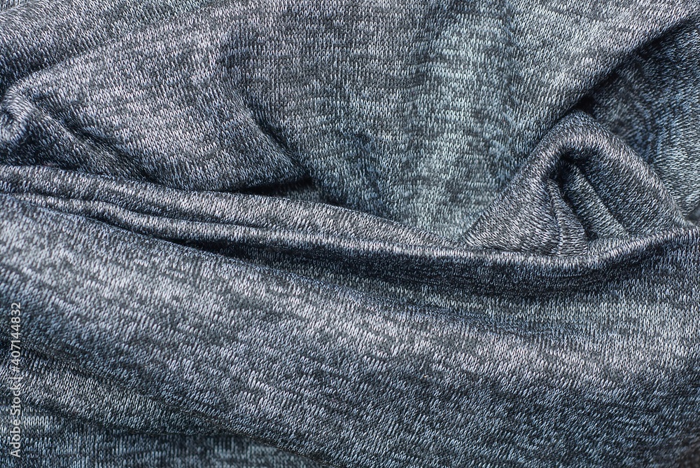 Fototapeta premium Gray dark texture of a piece of crumpled cloth from clothes