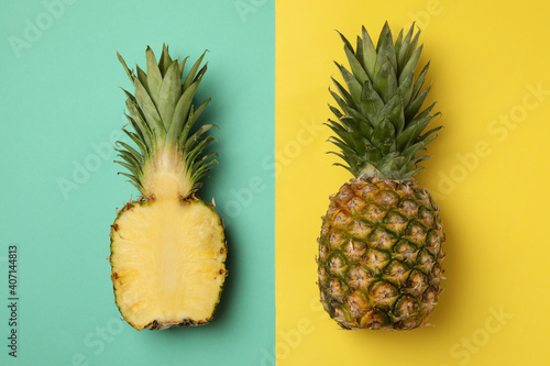 Tasty ripe pineapples on two tone background