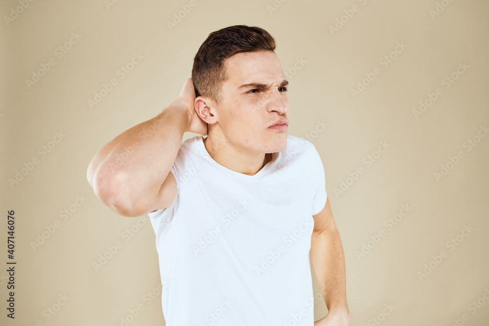Emotional man facial expression gesture with hands white t-shirt beige background Emotional man facial expression gesture with hands white t-shirt beige background