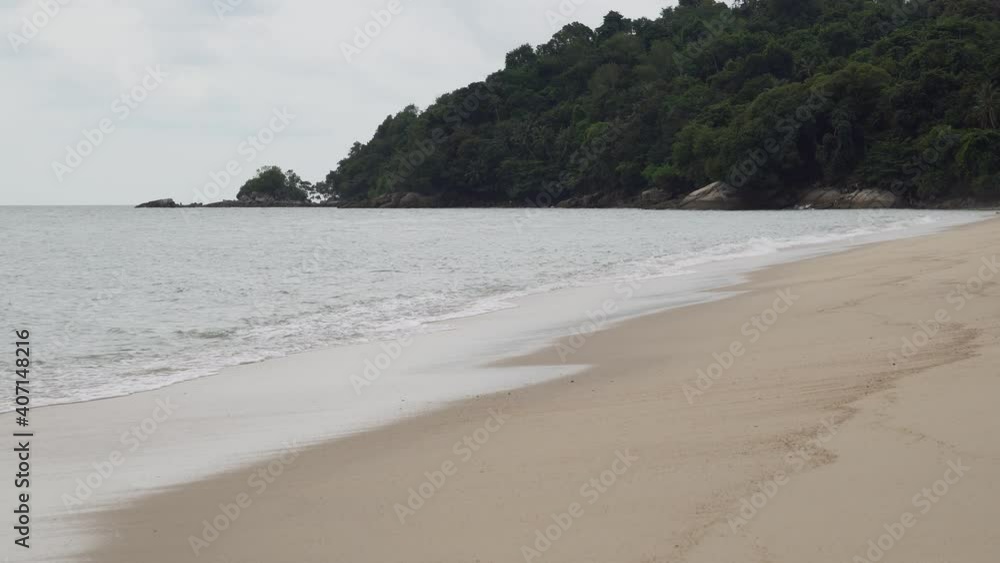 Gently wave at beach. Background is tropical rainforest. Gently wave at beach. Background is tropical rainforest.