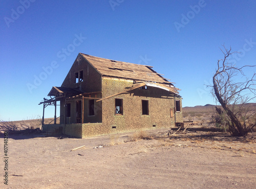 Abandoned house near route 66, California, United States. Photo in retro style. Added paper texture.