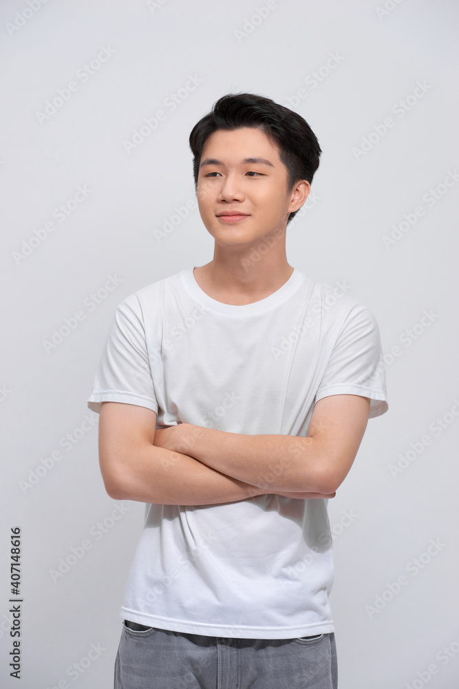 Portrait of young asian man isolated on white background, standing with crossed arms, smiling and looking straight at camera Portrait of young asian man isolated on white background, standing with crossed arms, smiling and looking straight at camera