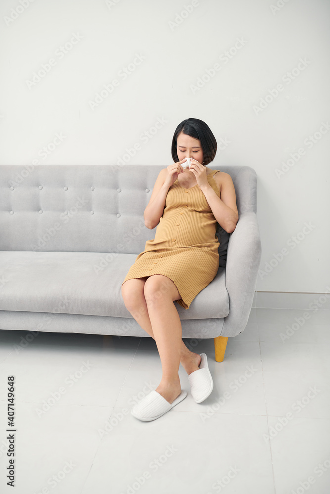 Asian pregnancy woman having a cough and cold fever sitting on sofa at home. Asian pregnancy woman having a cough and cold fever sitting on sofa at home.