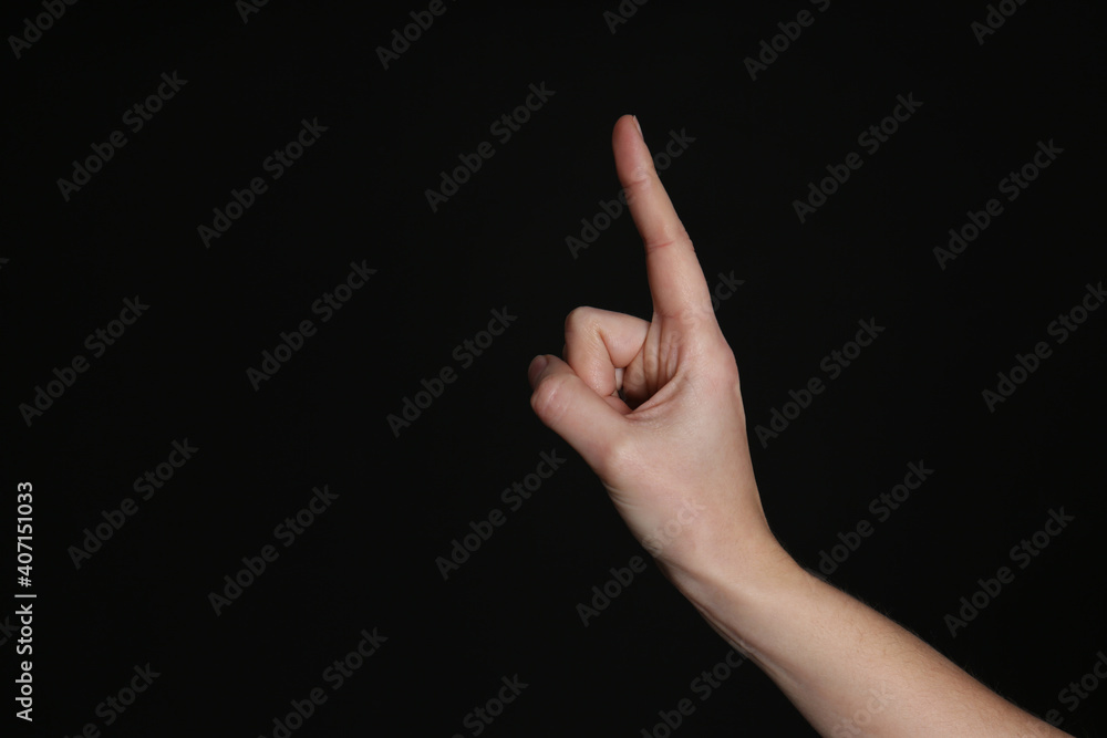 Woman pointing at something on black background, closeup. Finger gesture Woman pointing at something on black background, closeup. Finger gesture