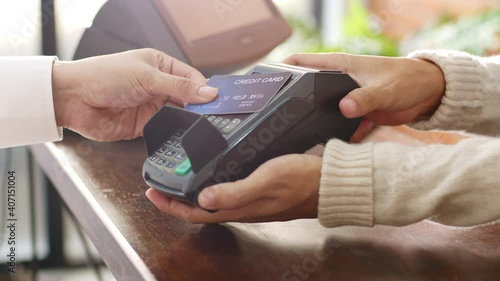 Customer using credit card for payment to owner at cafe restaurant, cashless technology and credit card payment concept