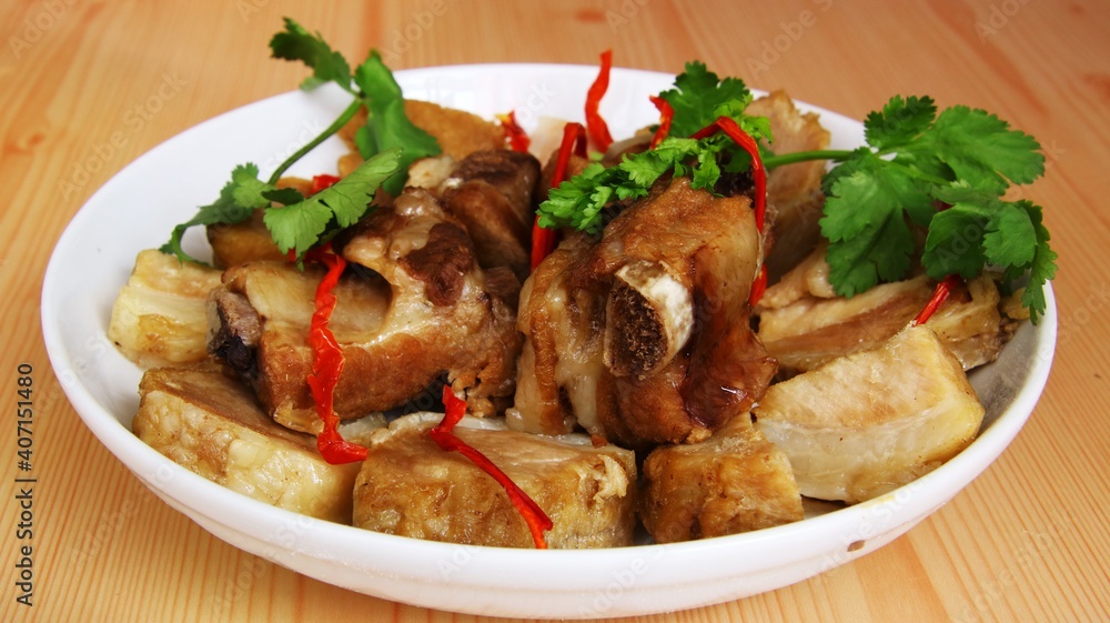 pork ribs garnished and red bell peppers in white porcelain plate