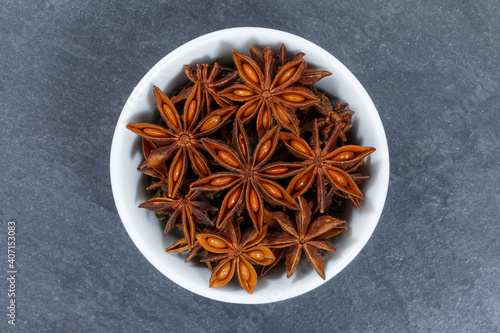 Star anise star-anise Christmas spice herb from above bowl on a slate