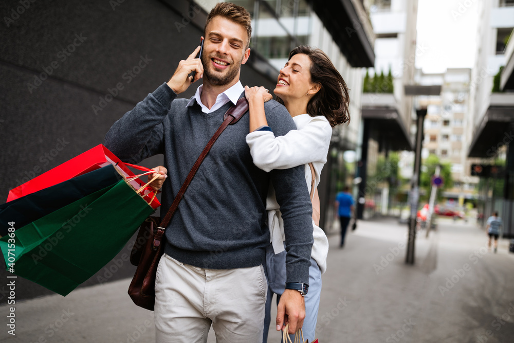 Happy couple with shopping bags in the city. People, sale, love and happiness concept. Happy couple with shopping bags in the city. People, sale, love and happiness concept.