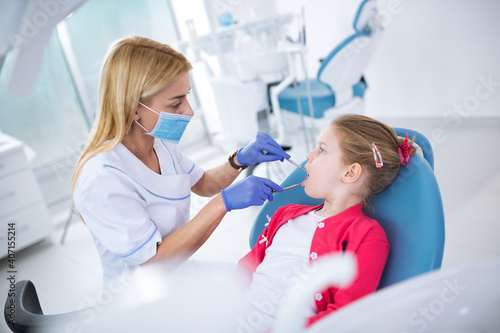 Dentist with sterile mask and dental instruments exam teeth