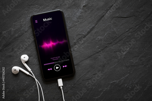 Music player on mobile phone with earphones photo