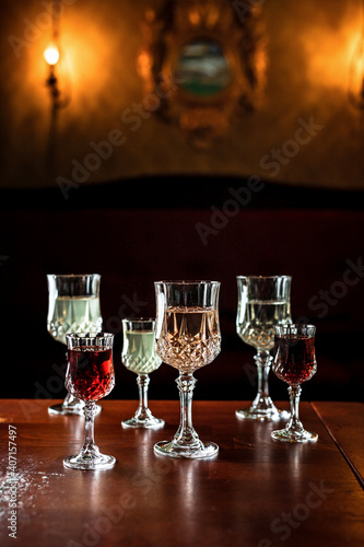 A variety of vintage glasses with different acloholic drinks, vermouth, cocktails, wine