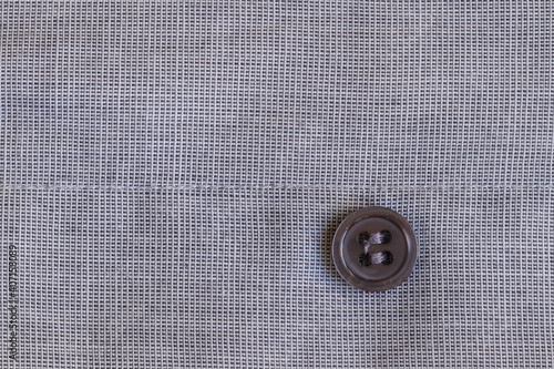 The texture of the fabric with a button for clothes.