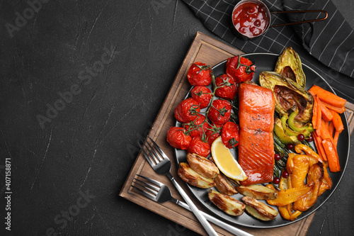 фотографія Tasty cooked salmon and vegetables served on black table, flat lay with space for text