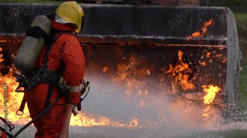 FHD Slow motion: Firefighter using Chemical foam fire extinguisher to fighting with the fire flame from oil tanker truck accident. Firefighter safety disaster accident and public service concept.