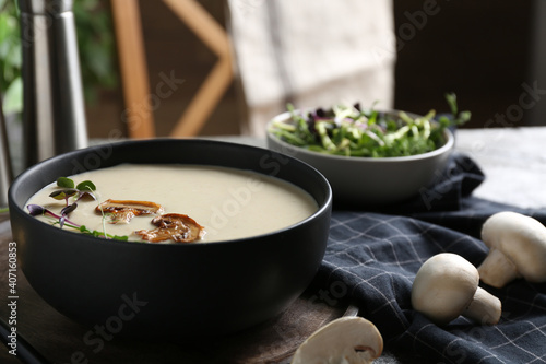 Delicious cream soup with mushrooms on table
