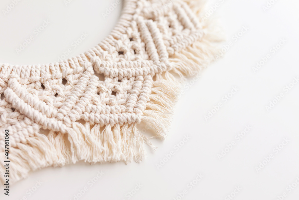 Macrame wreath on a white background close up. Natural cotton thread. Eco home decor. Copy space Macrame wreath on a white background close up. Natural cotton thread. Eco home decor. Copy space