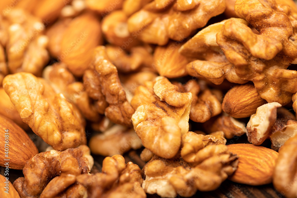 Almonds and walnuts scattered on the table. Close-up, selective focus. Almonds and walnuts scattered on the table. Close-up, selective focus.