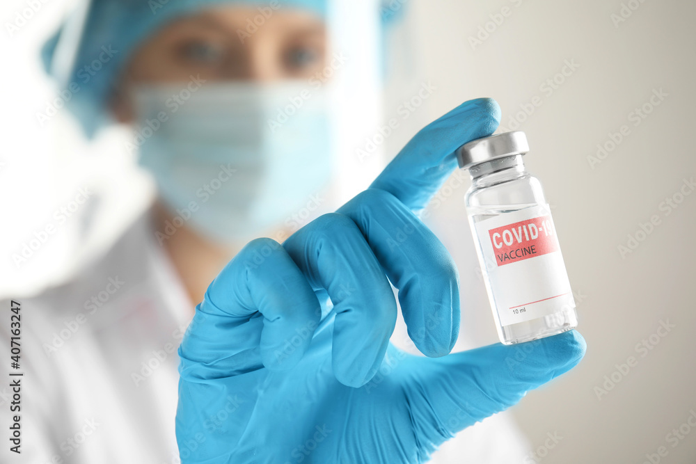 Fototapeta premium Doctor holding vial with vaccine against Covid-19, closeup