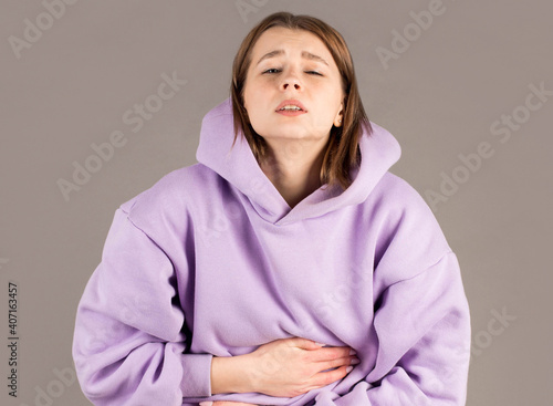 people, healthcare and problem concept - unhappy woman suffering from stomach ache photo