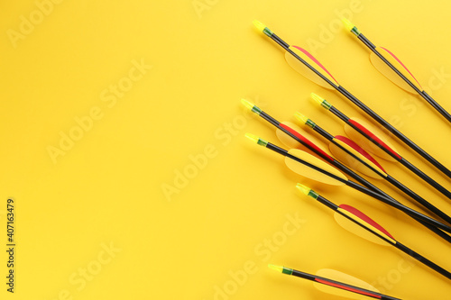 Принти на полотні Many arrows and space for text on yellow background, flat lay