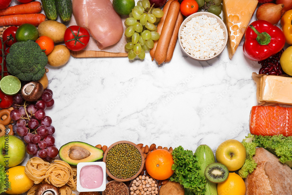 Frame of different products on white marble table, top view with space for text. Healthy food and balanced diet Frame of different products on white marble table, top view with space for text. Healthy food and balanced diet