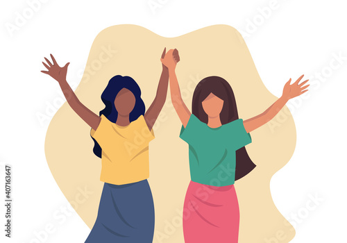 There are two happy young girls. One of them has dark skin, the other has light skin. They are holding hands. There is yellow background. These girls are friends. 