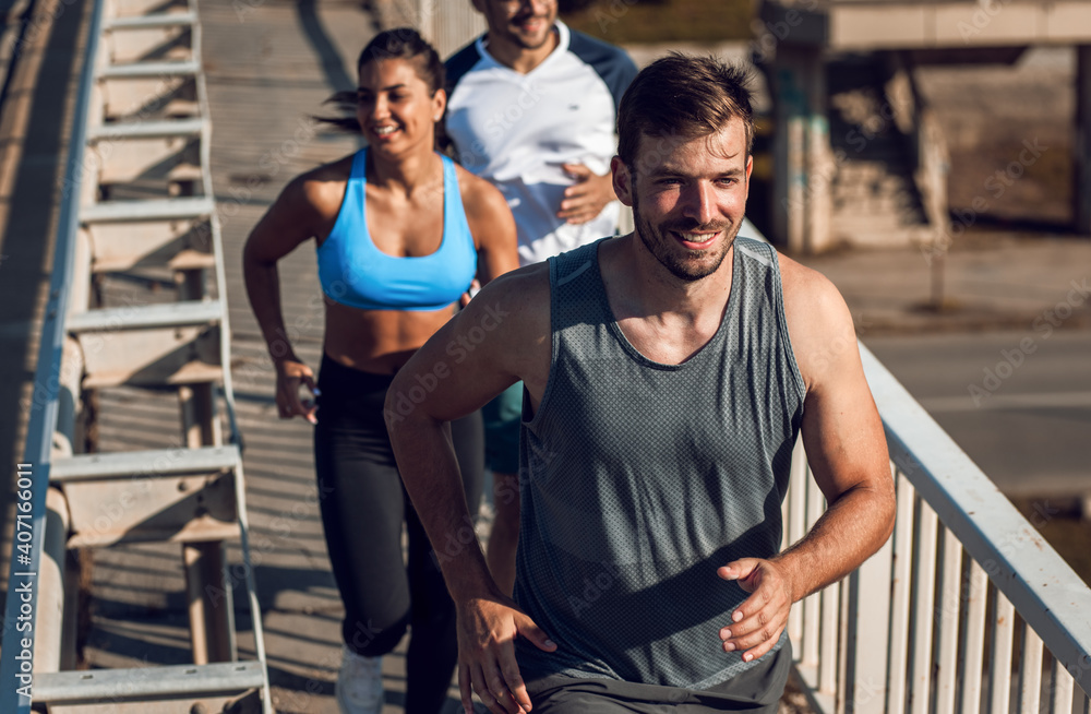 Group of sports people running in city street in morning. Group of sports people running in city street in morning.
