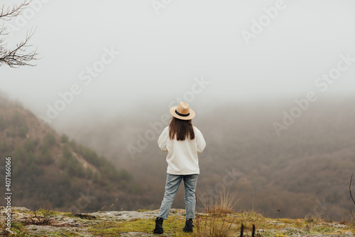 Top of mountain valley with fog on winter. Girl is relax into mountain in misty morning. Relax in nature. 