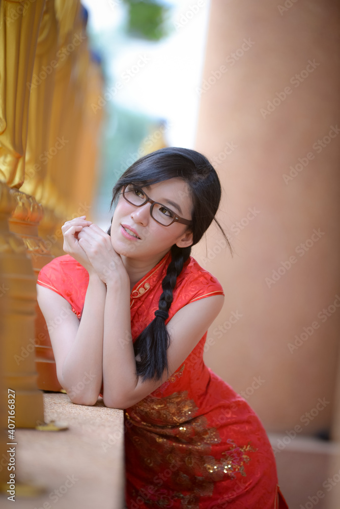 Fototapeta premium Action portrait beautiful Asian girl wearing Cheongsam green dress. the celebration of something in a joyful and exuberant way. Festivities and Celebration concept