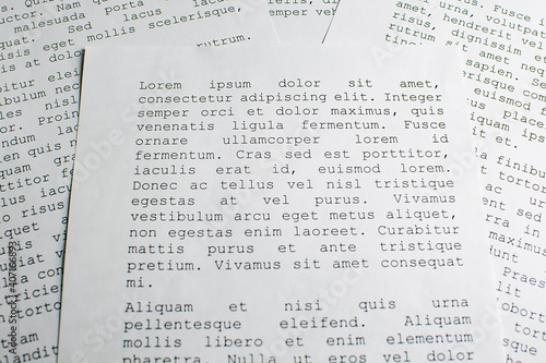 lorem ipsum dolor sit amet concept. selective focus photo of paper sheets with publishing and graphic design placeholder text on them. photo