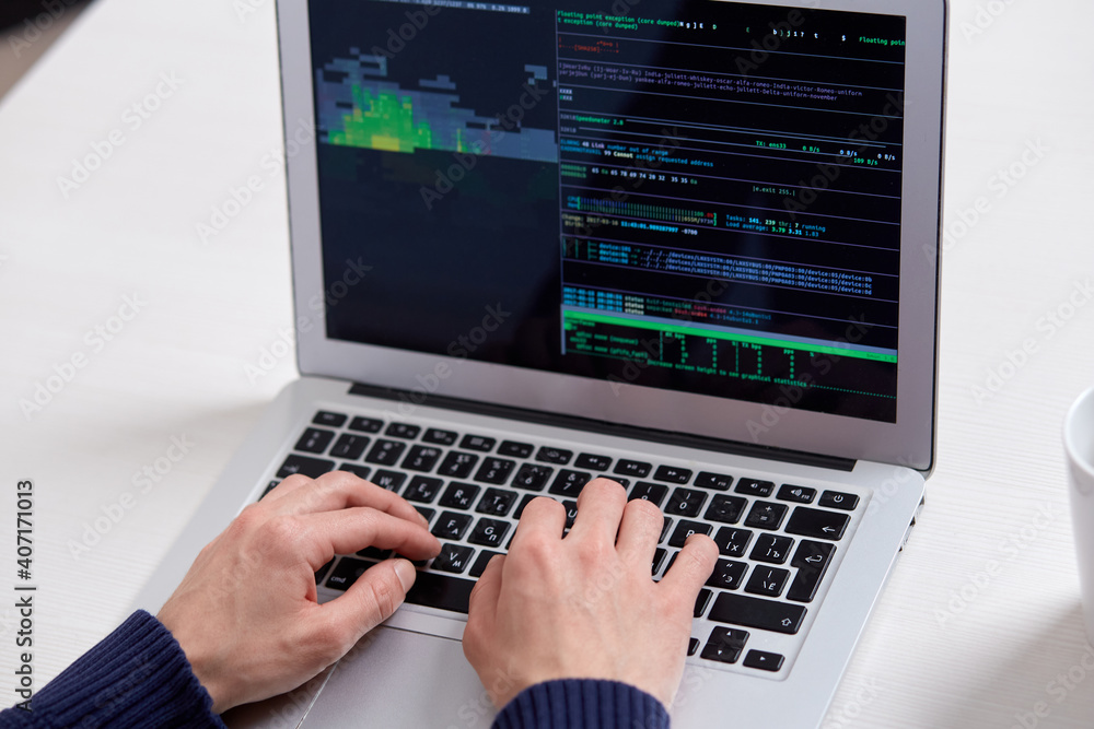 A man's hands on a laptop, numbers and codes on the screen. Work as a programmer. A man's hands on a laptop, numbers and codes on the screen. Work as a programmer.