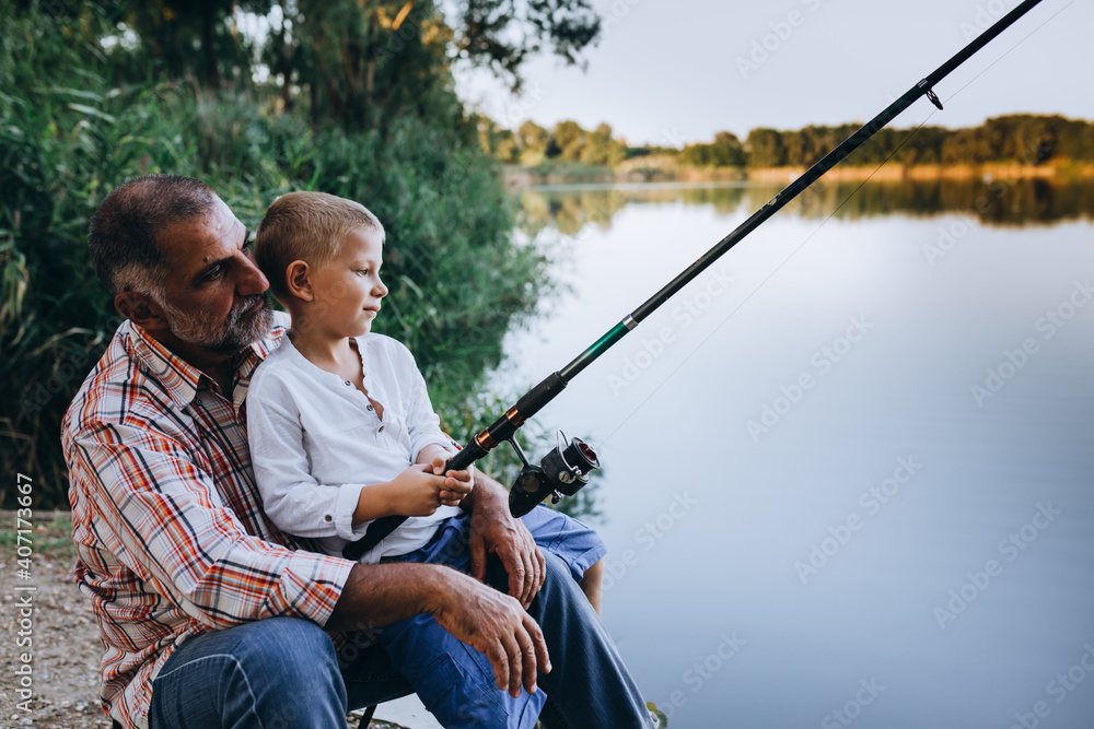 boy with his grandfather fishing together outdoor on the lake boy with his grandfather fishing together outdoor on the lake