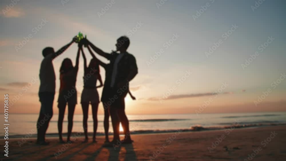 Blurred and Silhouette. A group of young Asian friends having fun drinking and dancing on the beach at sunset. Blurred and Silhouette. A group of young Asian friends having fun drinking and dancing on the beach at sunset.