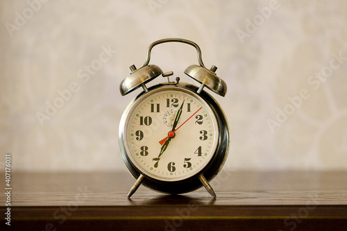 Alarm clock standing on the bedside table.