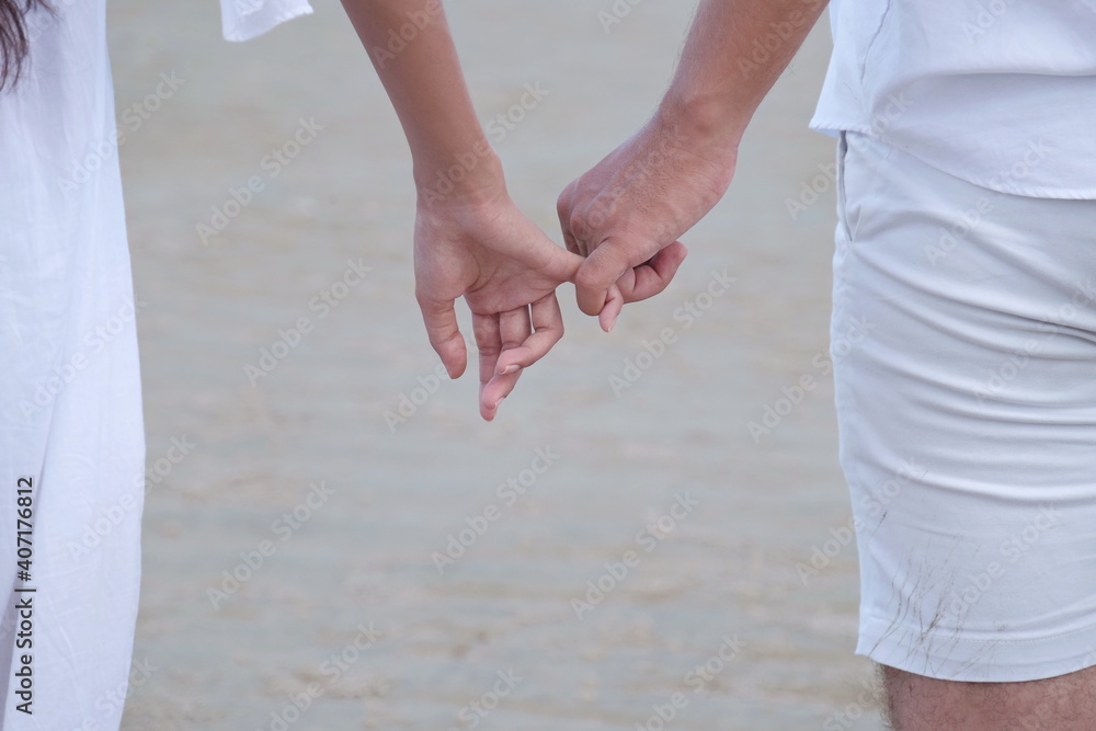 A romantic couple at the beach by the sea have white sand with the sound of waves and sunshine. With activities in the afternoon on a sweet holiday