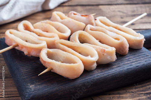 Fotografie Fried squid rings on a skewer with tomato sauce and lemon